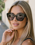Velvet Eyewear Sunglass Maya in black and a part of the Velvet Eyewear Summer Edit Collection worn by our model Mia