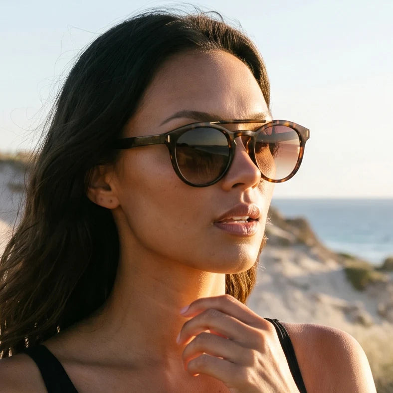 Amelia for Women by Velvet Eyewear. Best for Oval, Square, and Heart Face Shapes. All Seasonal Palettes. Worn by our model, Rocky standing on the edge of a cliff.
