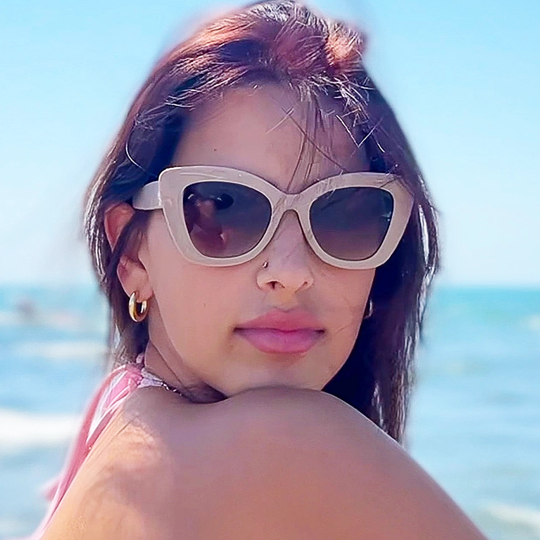 Woman wearing angular sunglasses by Velvet Eyewear designed for a round face shape