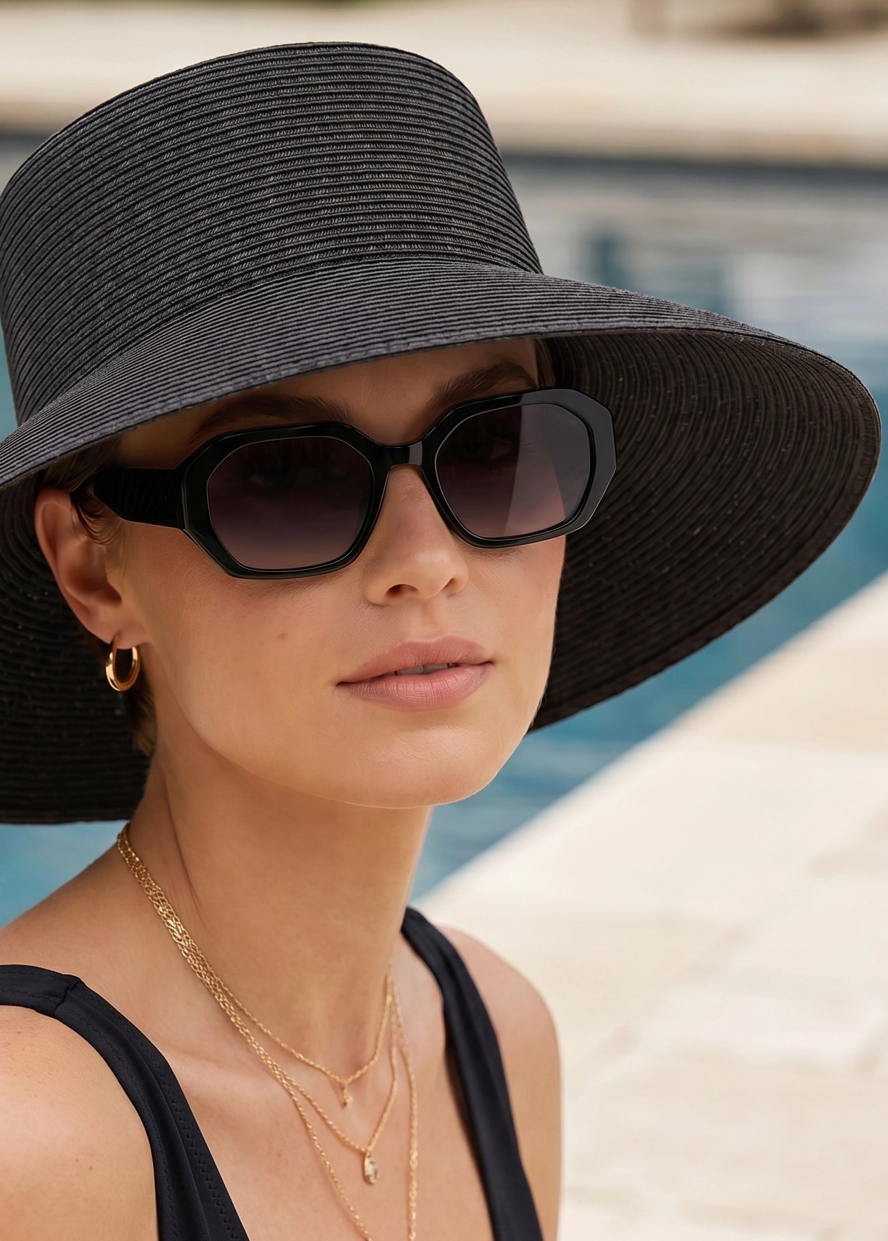 Woman wearing the Velvet Trends® Audrey UPF50 sun hat in black with the Velvet Eyewear sunglass style Nina in black. Elegant resort-inspired styling.