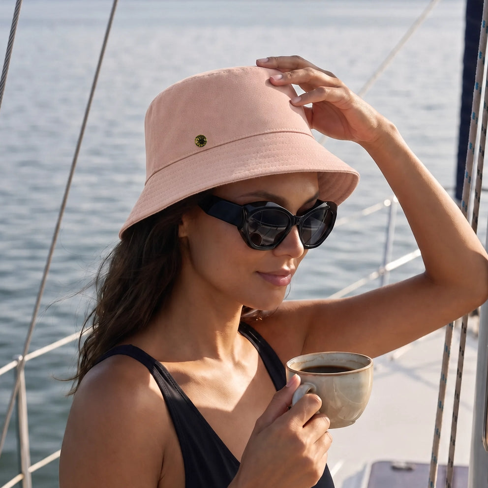 Velvet Trends pink bucket hat featured with the Alice polarized sunglass in black on our model Rocky on the sailboat